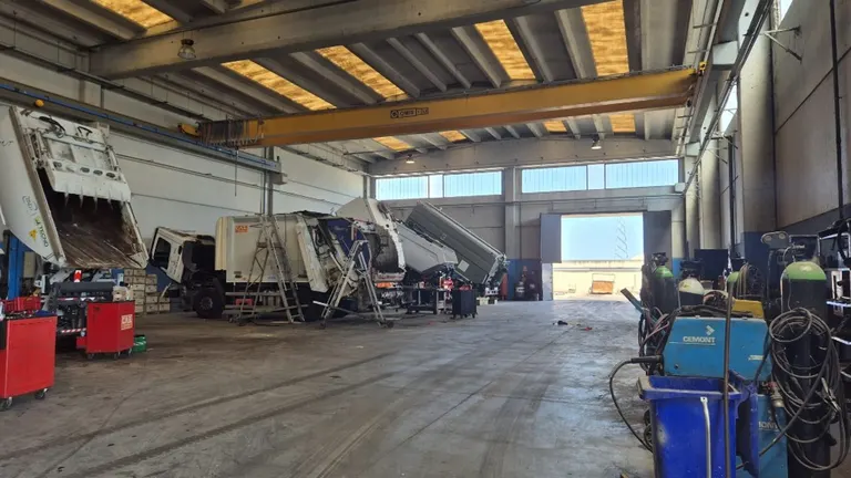 Capannone officina C.A.B. con mezzi per l'igiene urbana in lavorazione